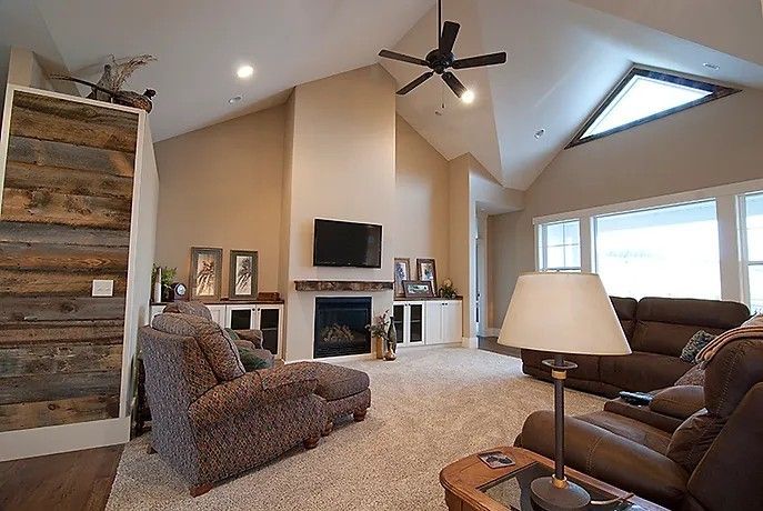 A living room with a ceiling fan and a fireplace