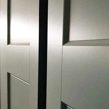 A close up of a white door with a black frame.