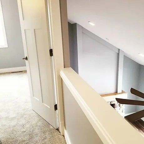 A staircase leading up to a bedroom with a ceiling fan.