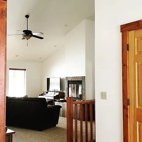 A living room with a ceiling fan and a fireplace