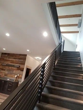 A set of stairs leading up to the second floor of a house with a metal railing.