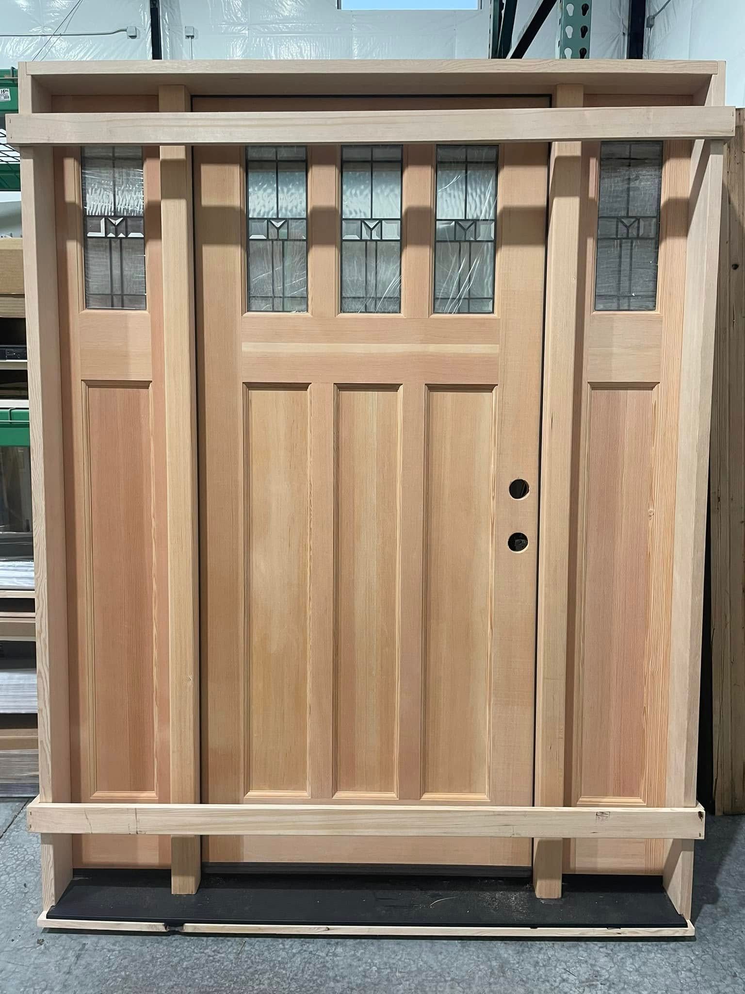 Wooden Craftsman-style front door with glass panels above and on the sides, light-colored wood.