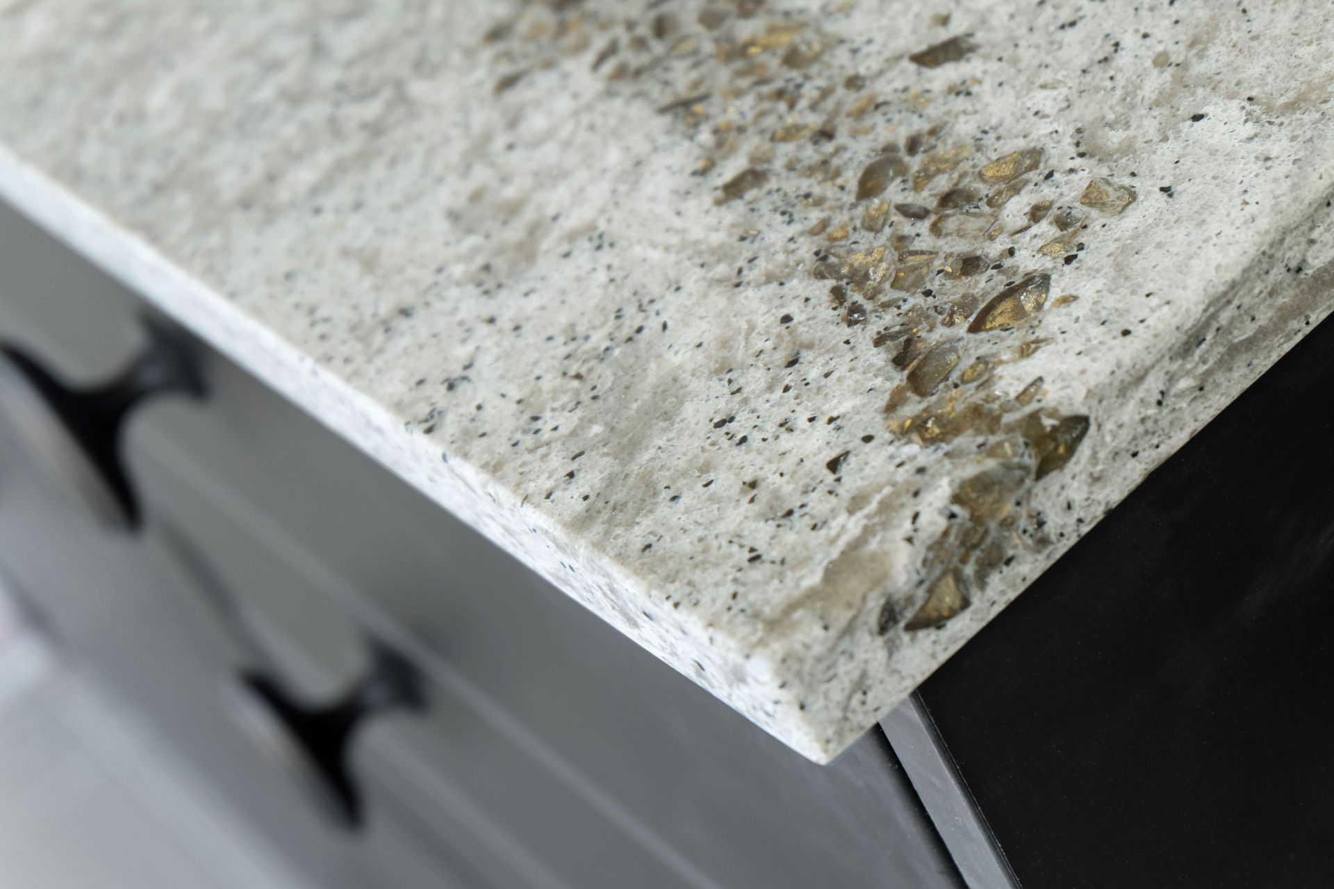 Close-up of a weathered stone countertop corner with stains and chipped edge