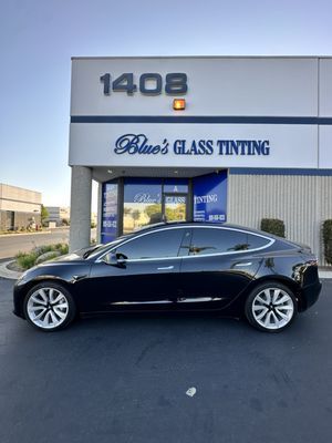 Black sedan parked outside Blue's Glass Tinting shop with address 1408.