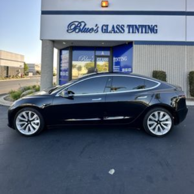 Black sedan parked outside Blue’s Glass Tinting storefront