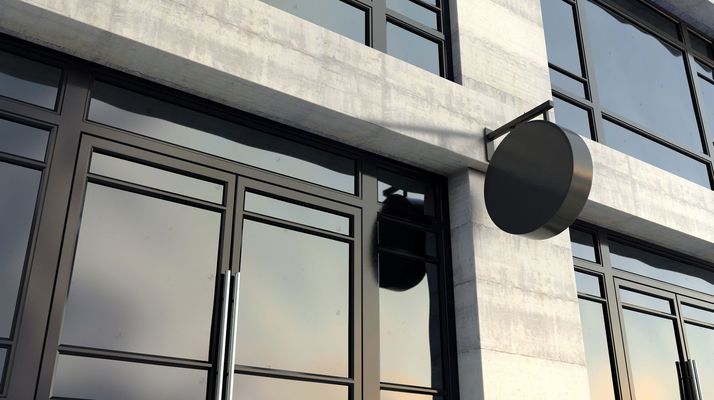 Modern building facade with large windows and round black wall lights