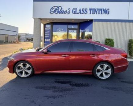 Red sedan parked outside Blue’s Glass Tinting storefront