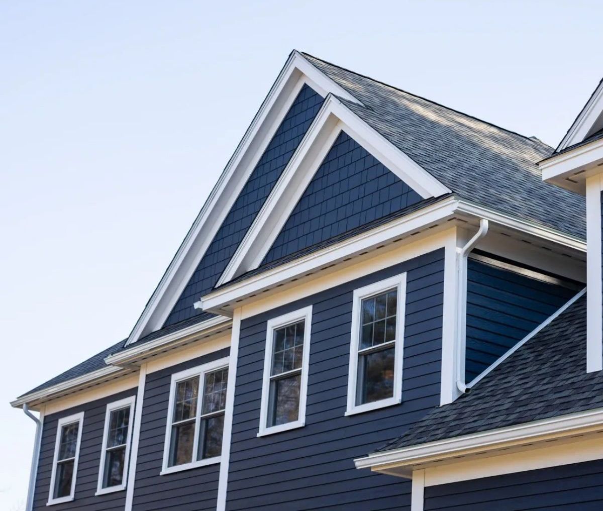 A blue house with white trim and a gray roof