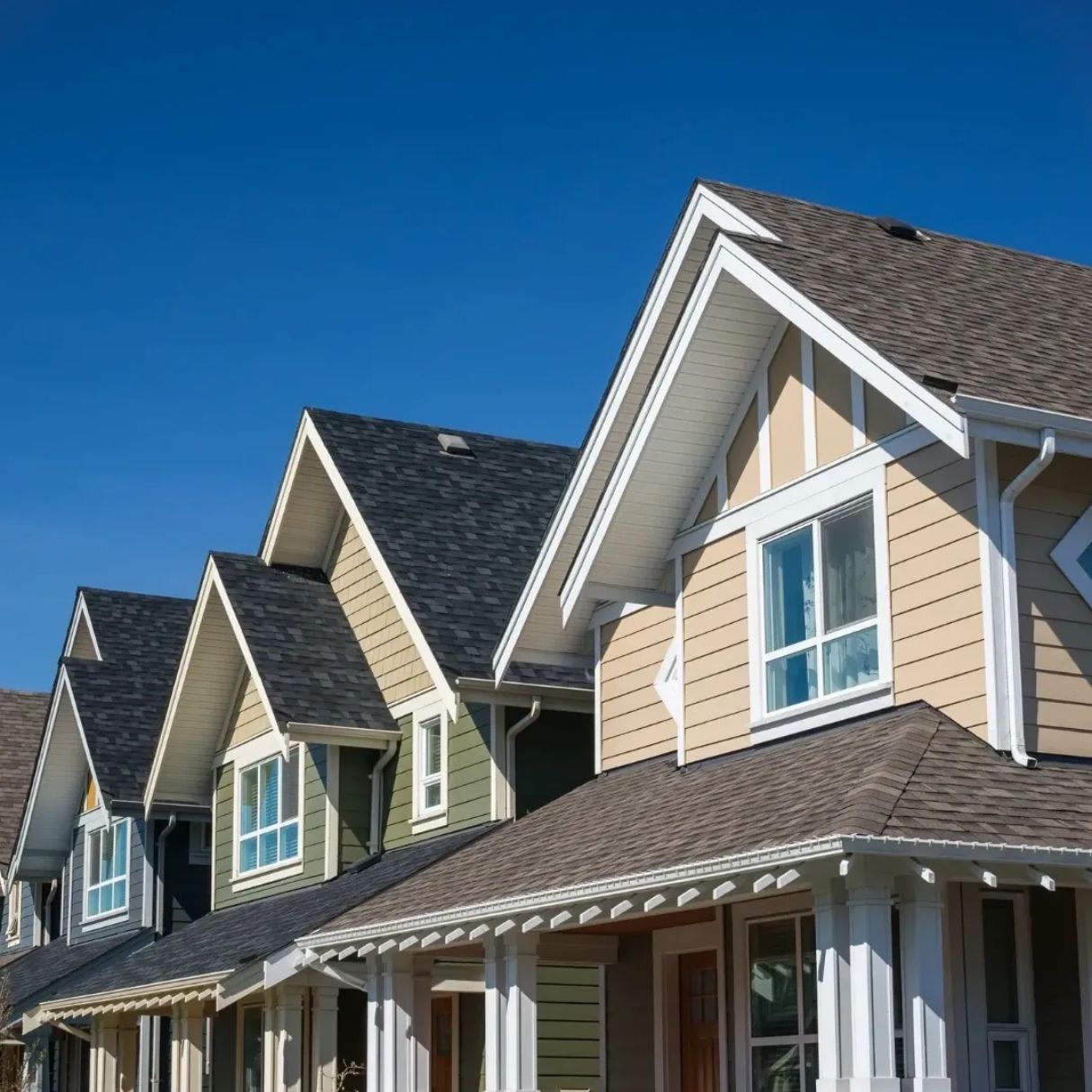 A row of houses with a blue sky in the background