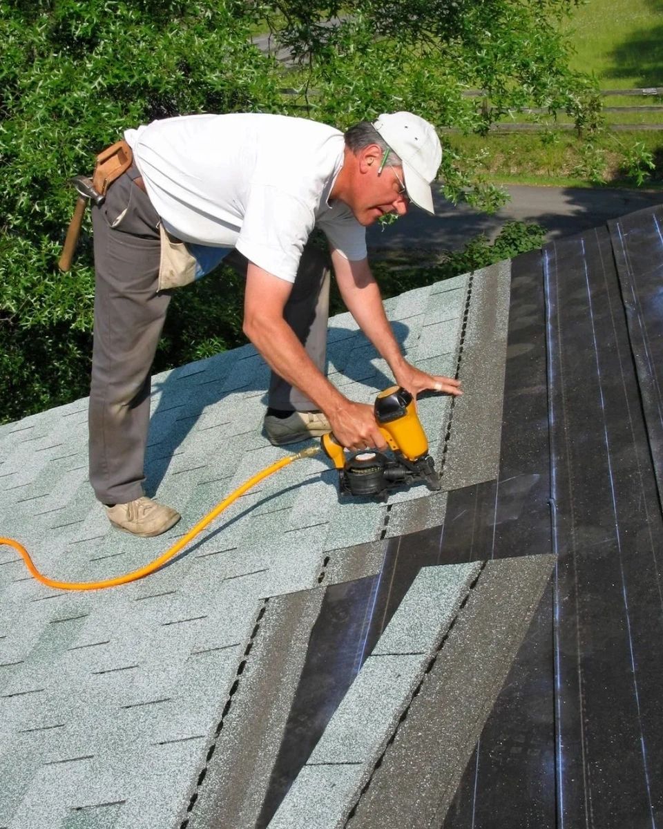 A man is working on the roof of a house