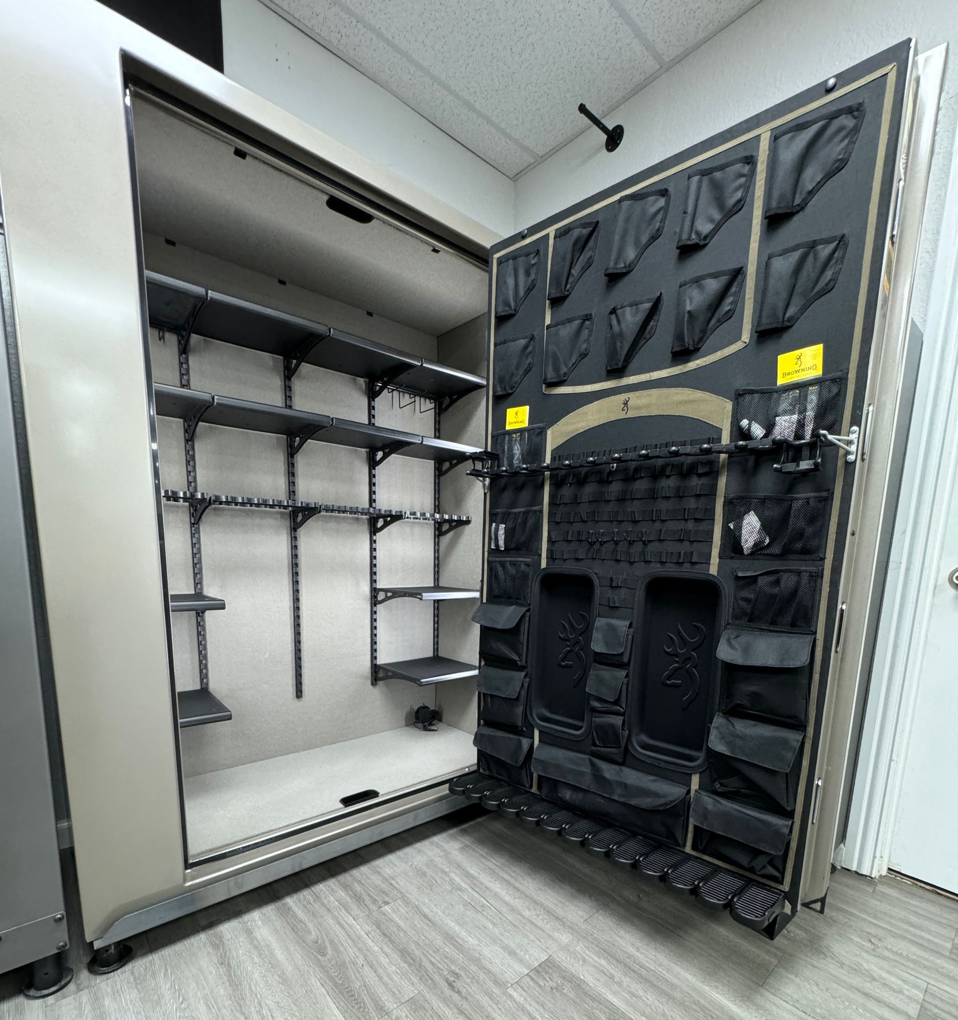A large safe with a lot of shelves and pockets is open in a room.