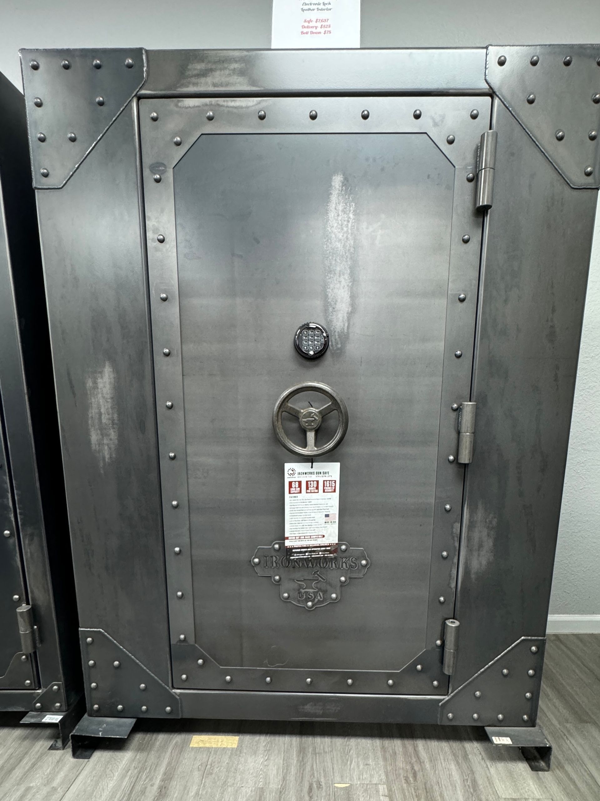 A large metal safe is sitting on a wooden floor.