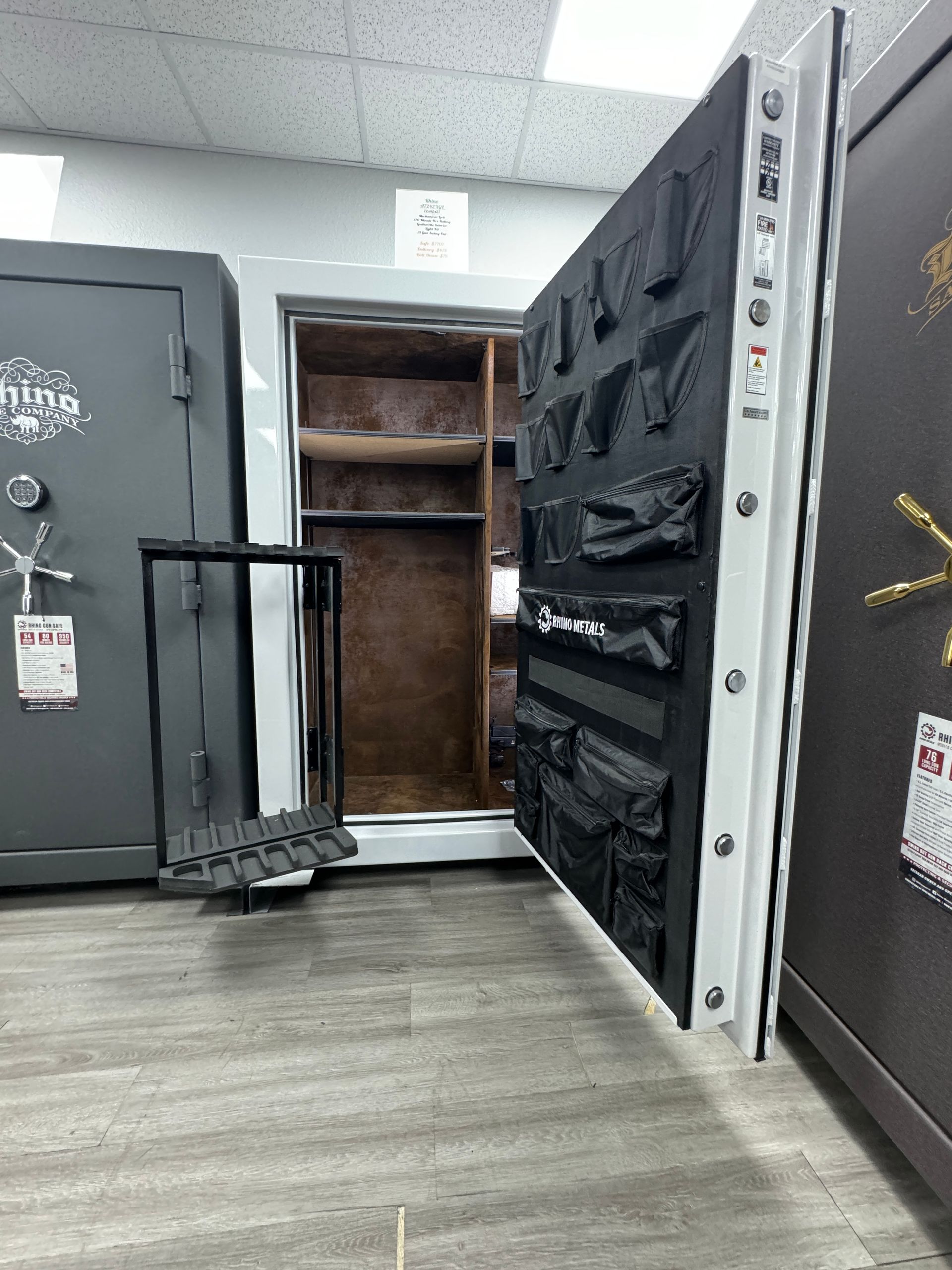 A safe with the door open in a room with other safes.