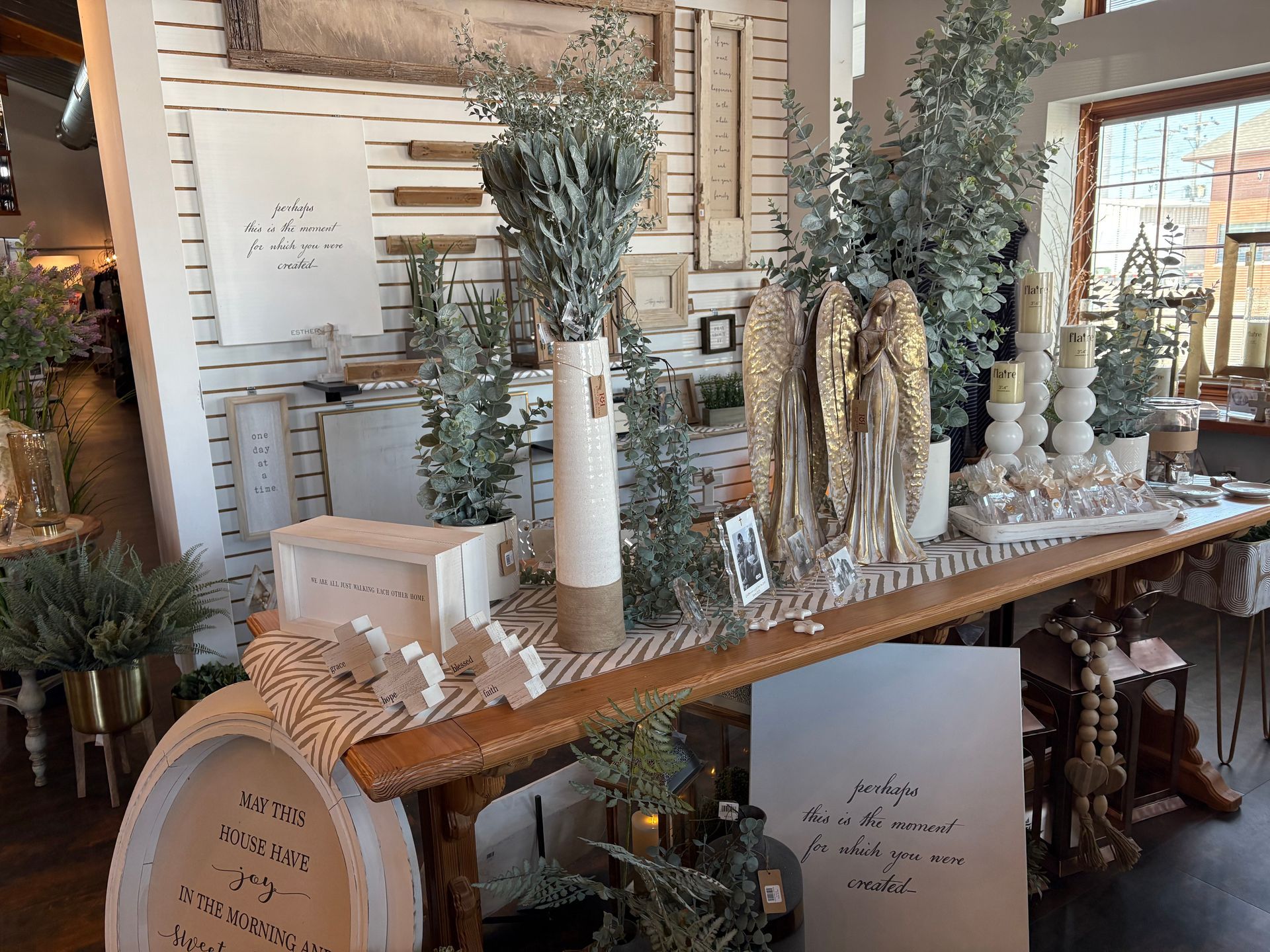 A long wooden table with a lot of plants on it in a room.
