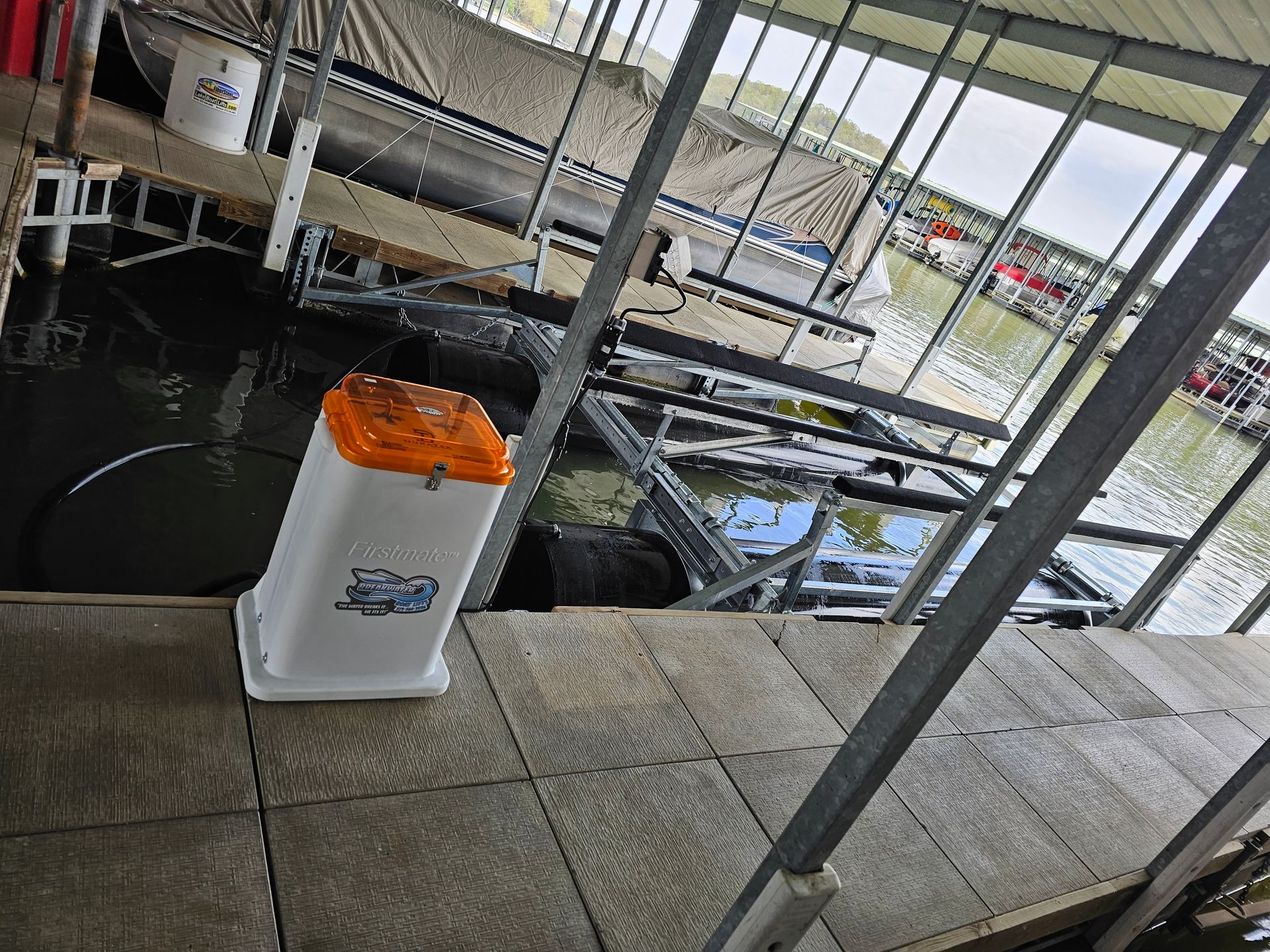 A boat is docked at a dock next to a trash can.