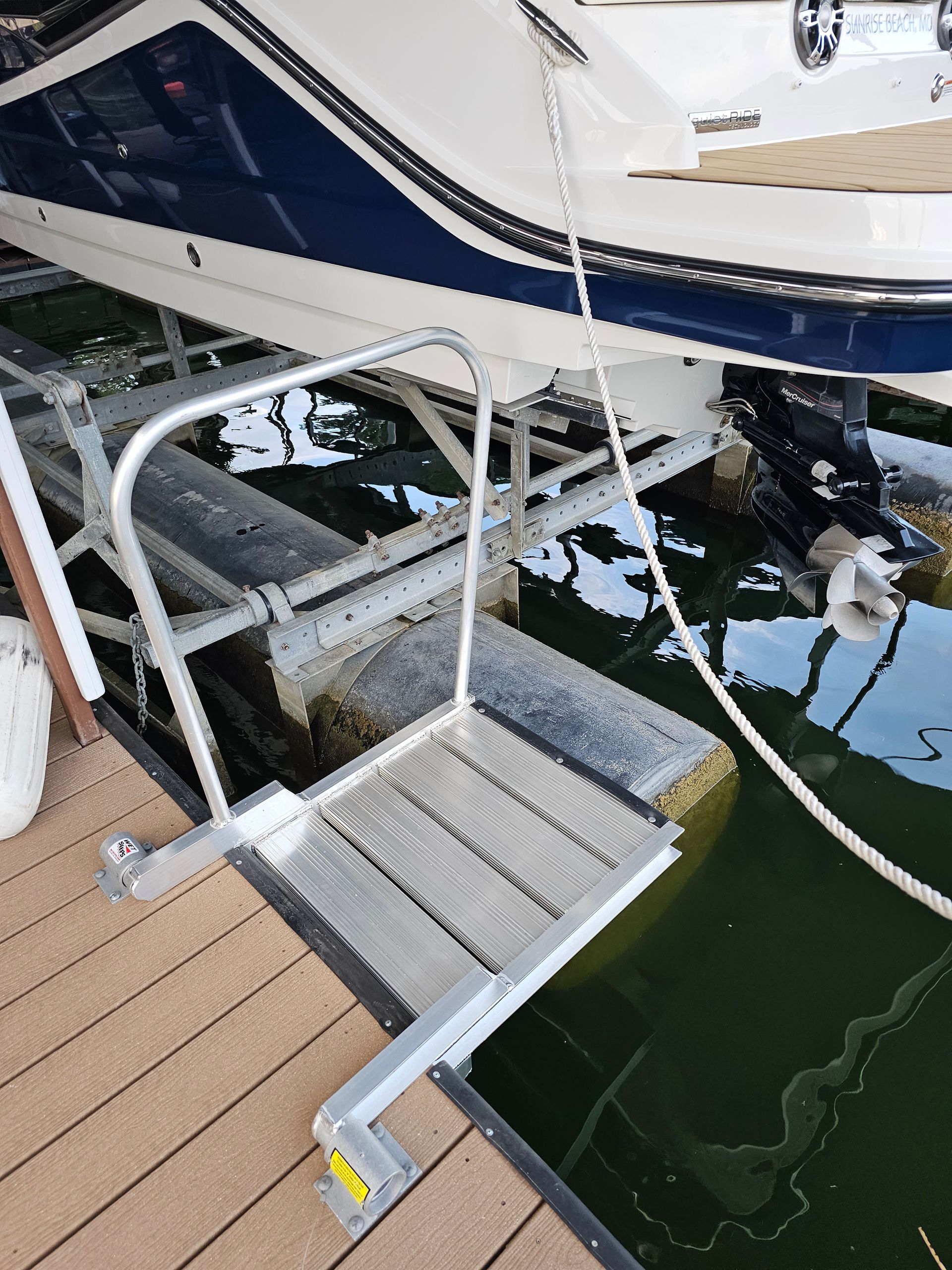 A boat is docked at a dock with stairs leading to it.