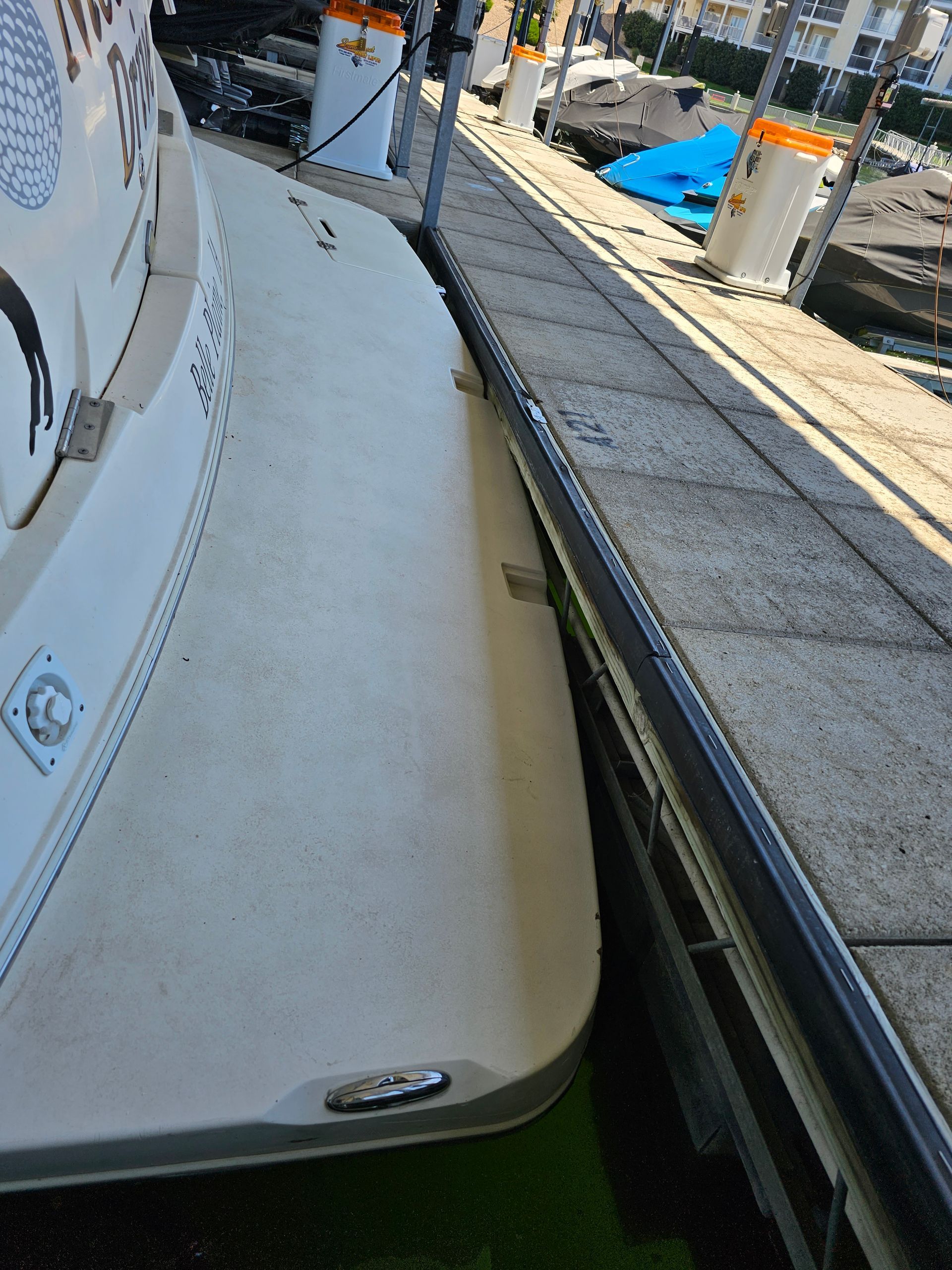A boat is docked at a dock next to a concrete wall.