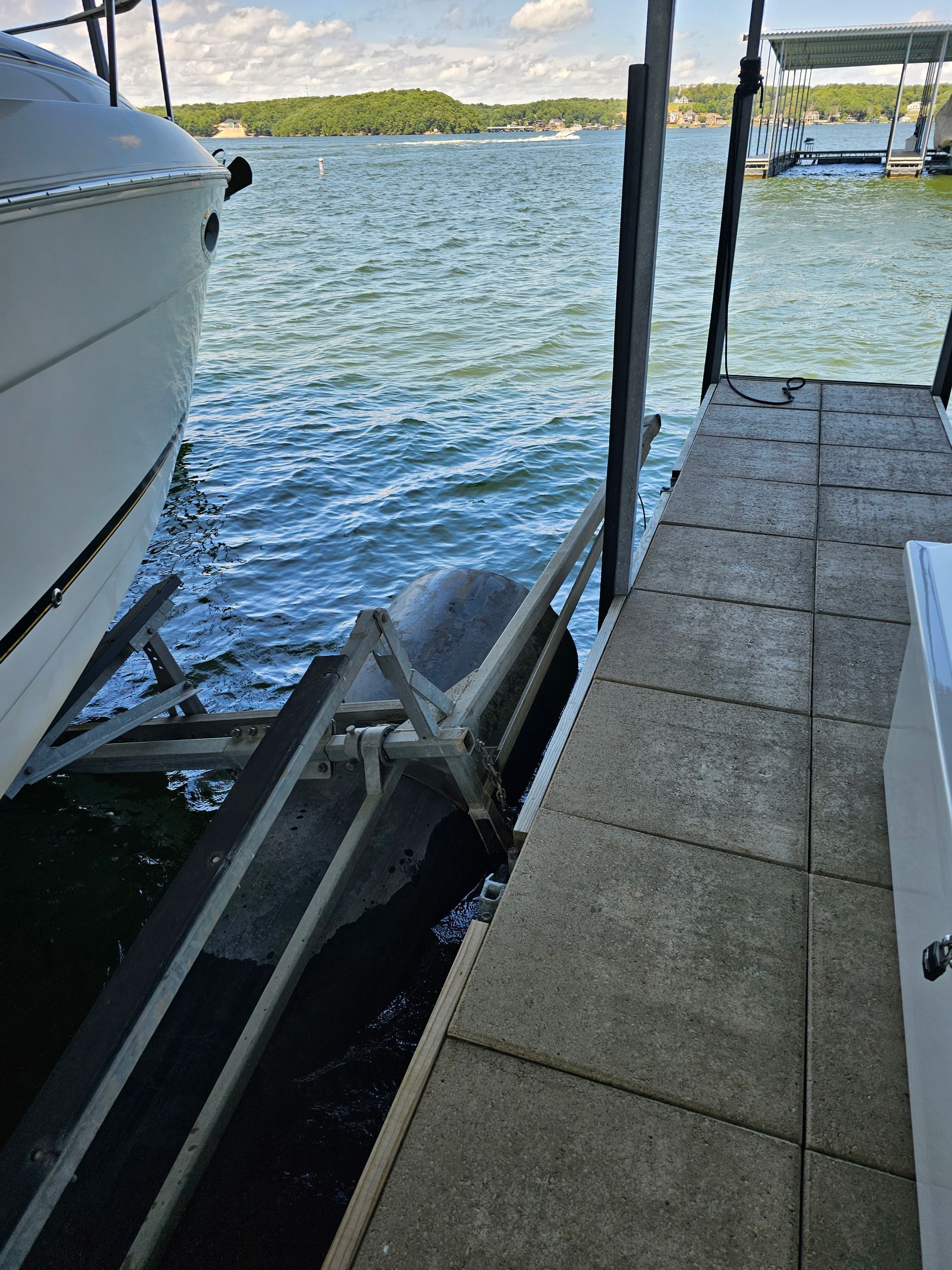 A boat is sitting on a dock next to a body of water.