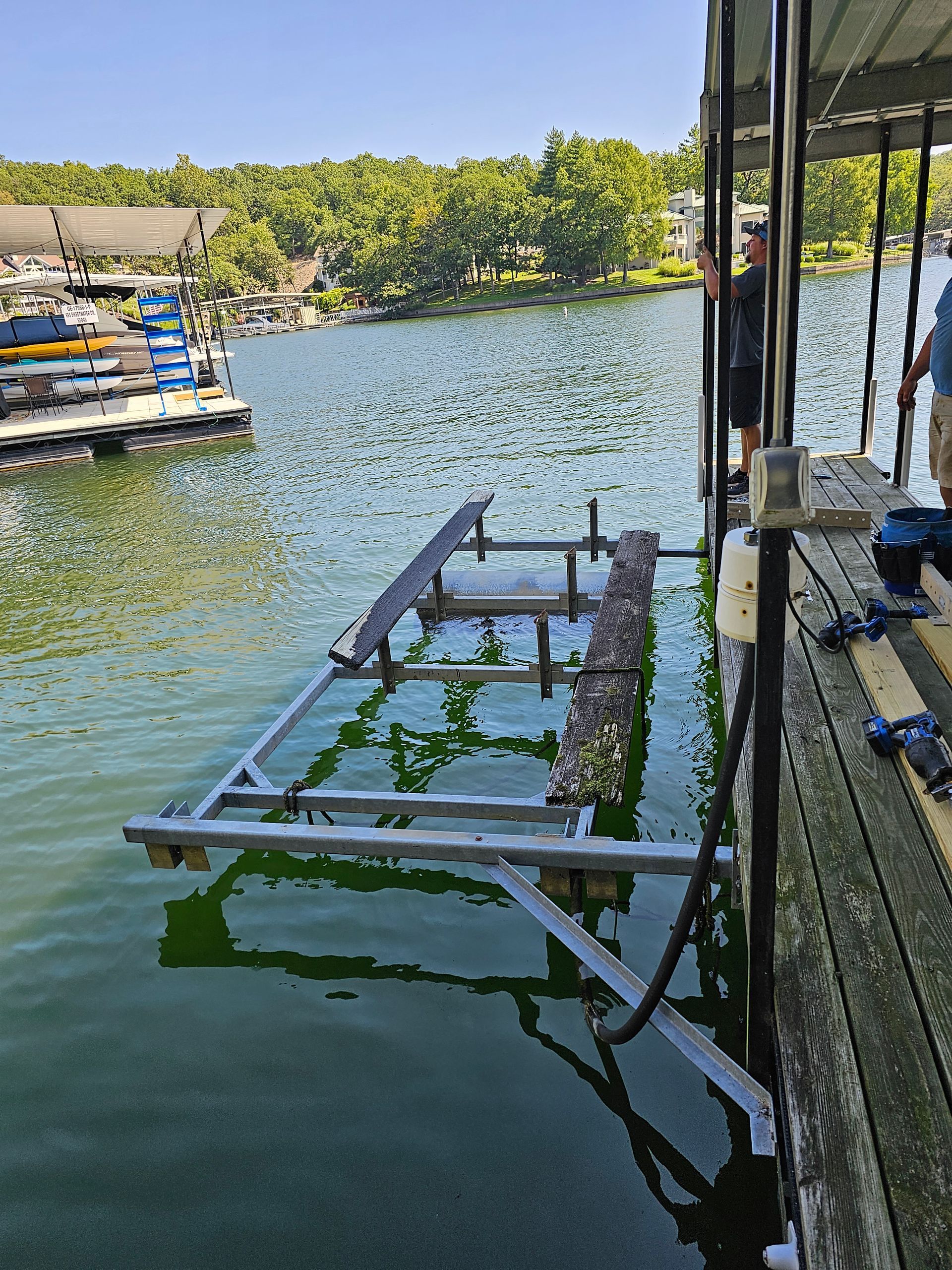 A man is standing on a dock overlooking a lake.