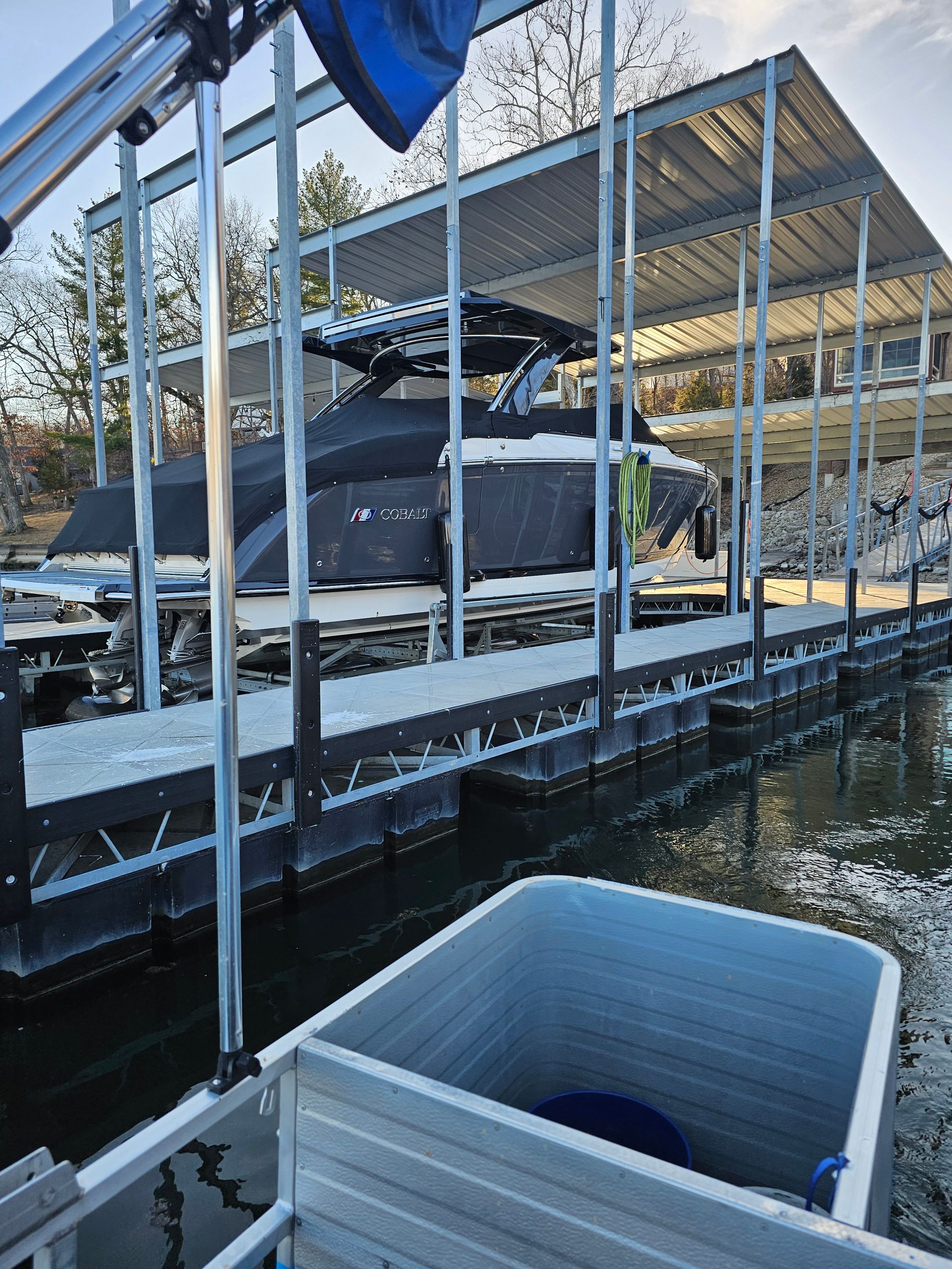 A boat is docked at a dock with a boat cover on it