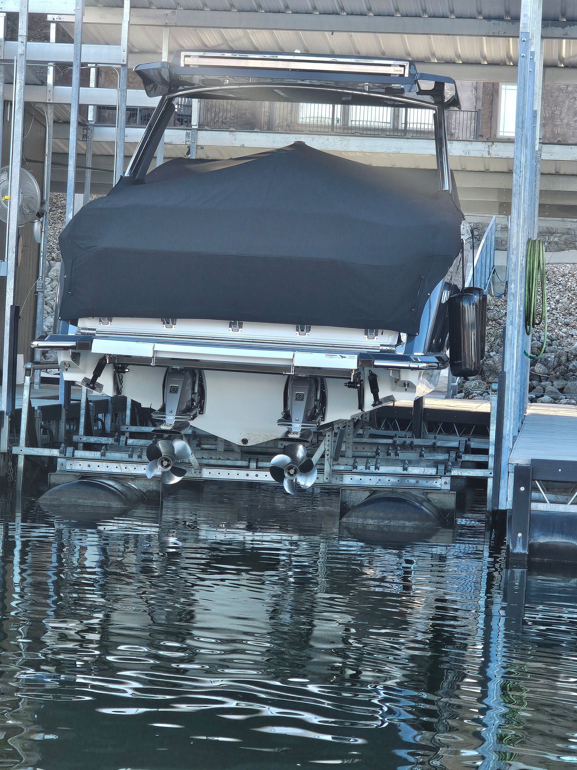A boat is docked at a dock with a black cover on it