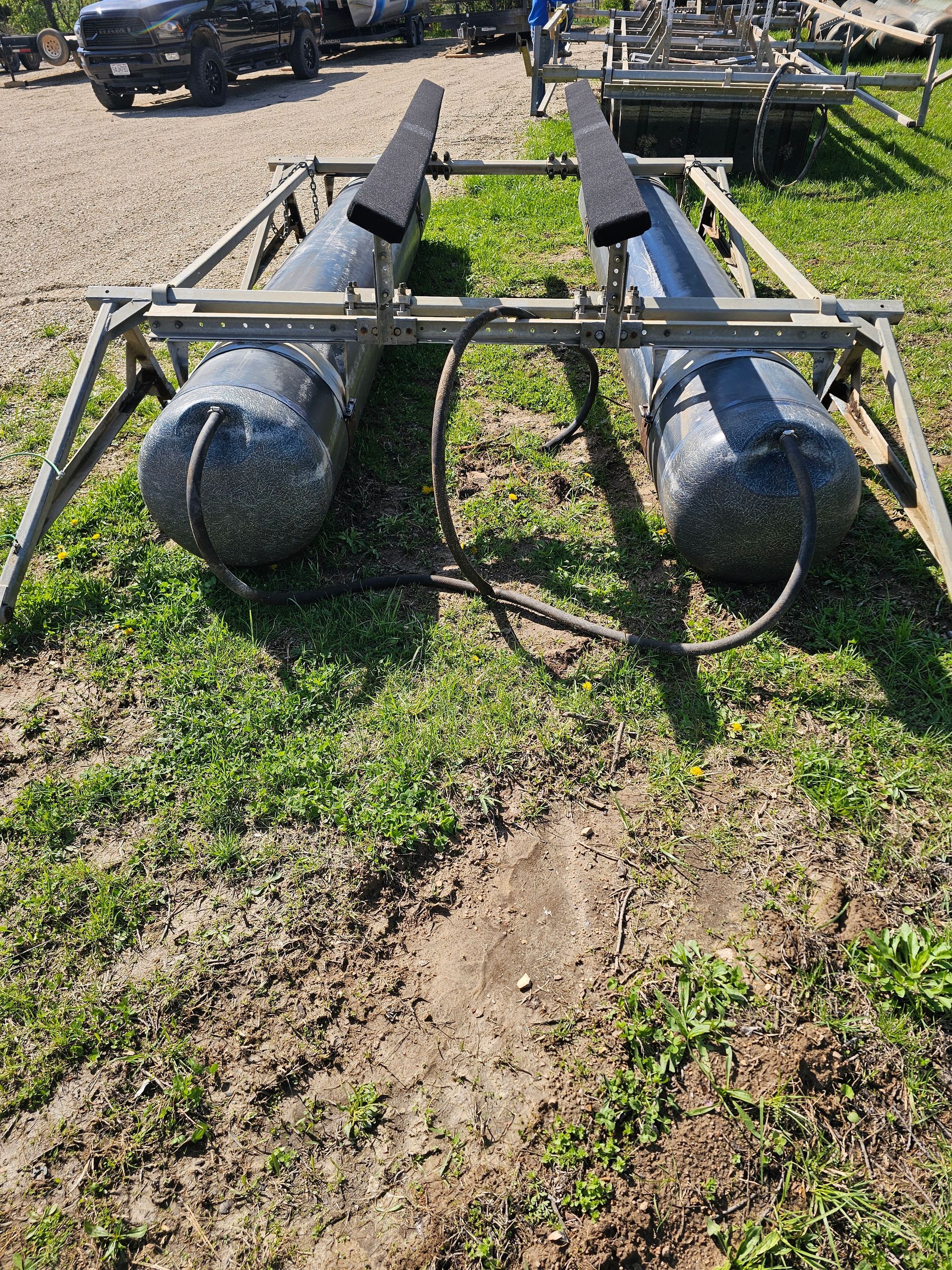 A boat trailer is sitting on top of a lush green field.