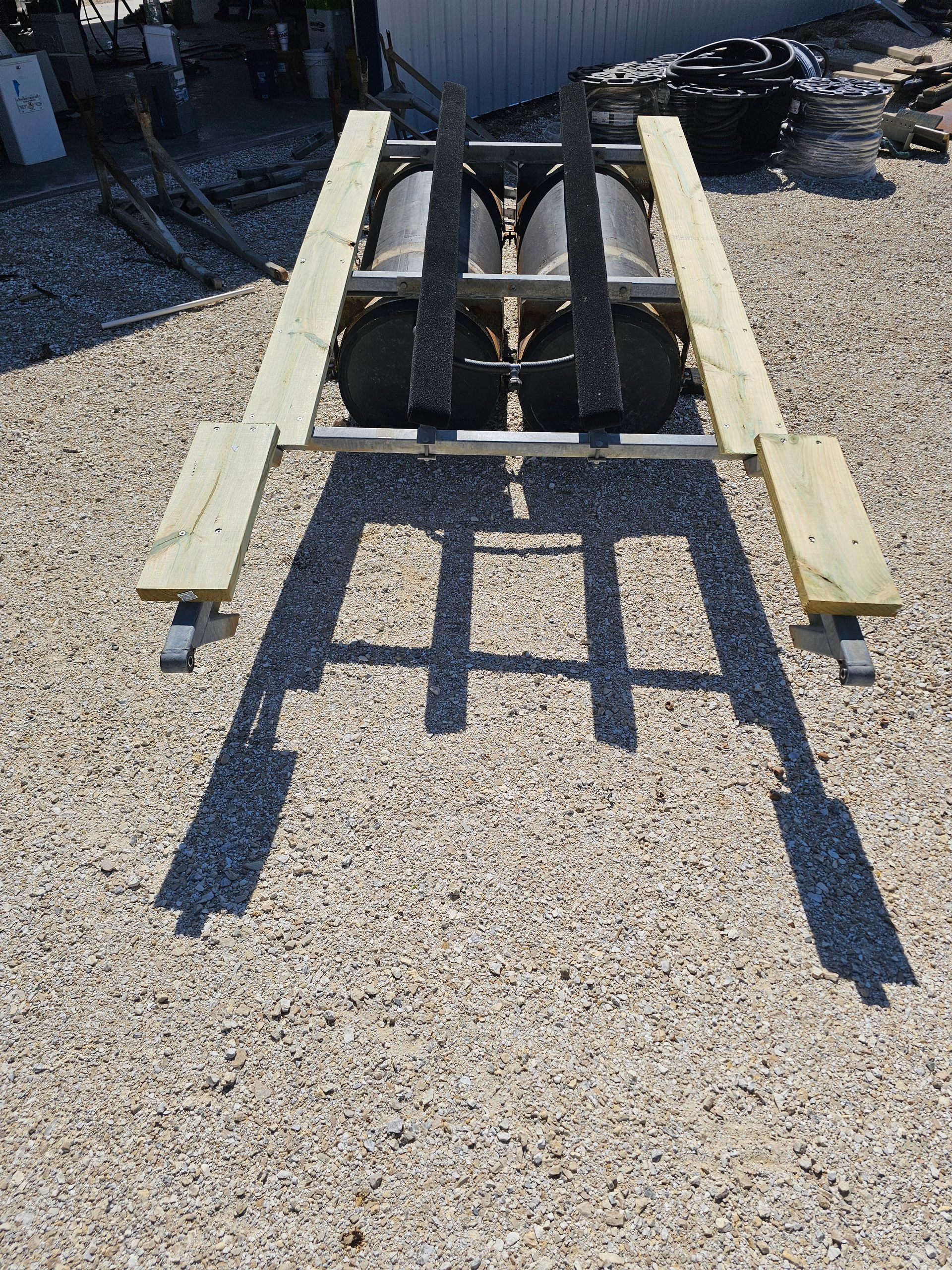 A wooden picnic table with two benches is sitting on gravel.