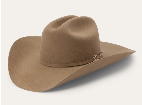 A tan felt cowboy hat with a cattleman crease and a silver buckle hatband against a neutral background.