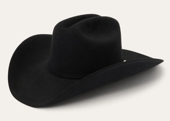 A solid black felt cowboy hat with a curved brim against a neutral, off-white background.