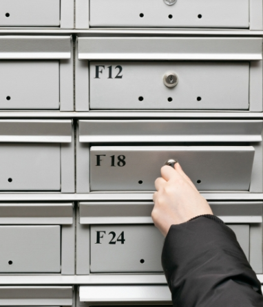 Hand turning a key on a gray locker labeled F18, with F12 and F24 nearby.