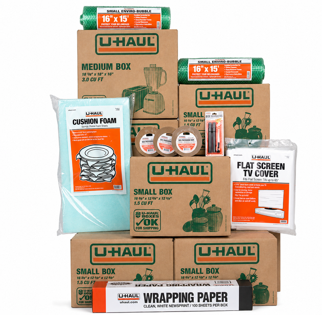Stacked U-Haul moving boxes with packing supplies in orange, brown, white, and green