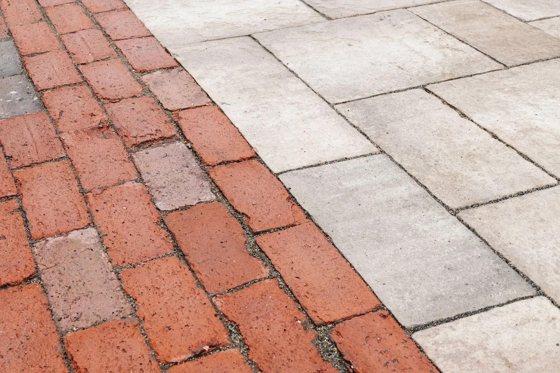 Red brick and light gray paving stones arranged in a diagonal walkway pattern.