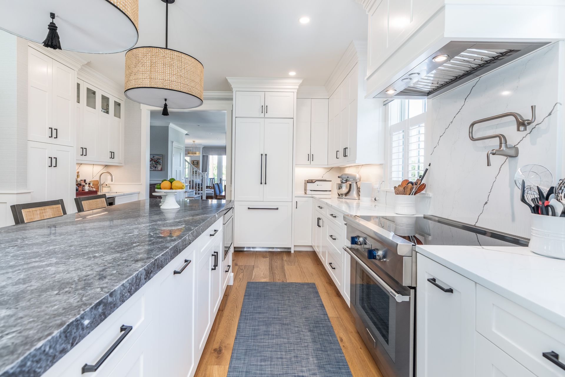 Bright modern kitchen with white cabinets, gray countertops, and stainless steel appliances.