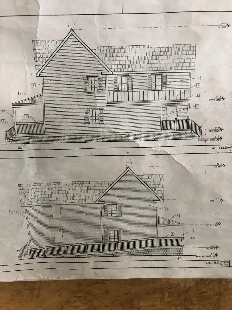 Architectural drawings of a two-story house with a pitched roof, depicting front and side elevations.