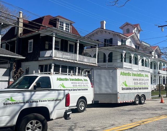 White truck and trailer with Atlantic Insulation logo in front of historic houses.