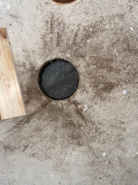 Black hockey puck on gray surface with wooden board.