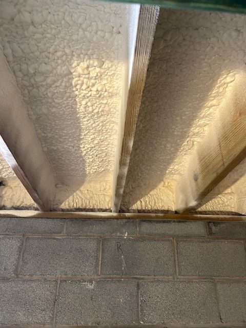 Close-up of insulated ceiling panels above a cinder block wall.