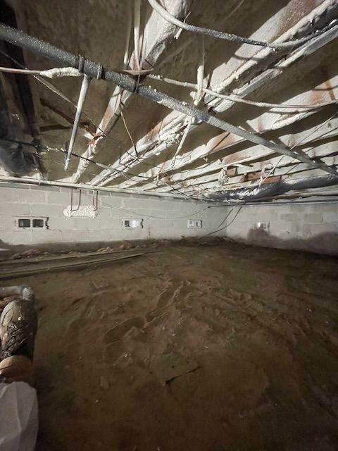 Unfinished basement with exposed beams, ductwork, and dirt floor under construction