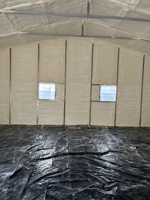 Inside a beige tent with two small windows and a black tarp floor