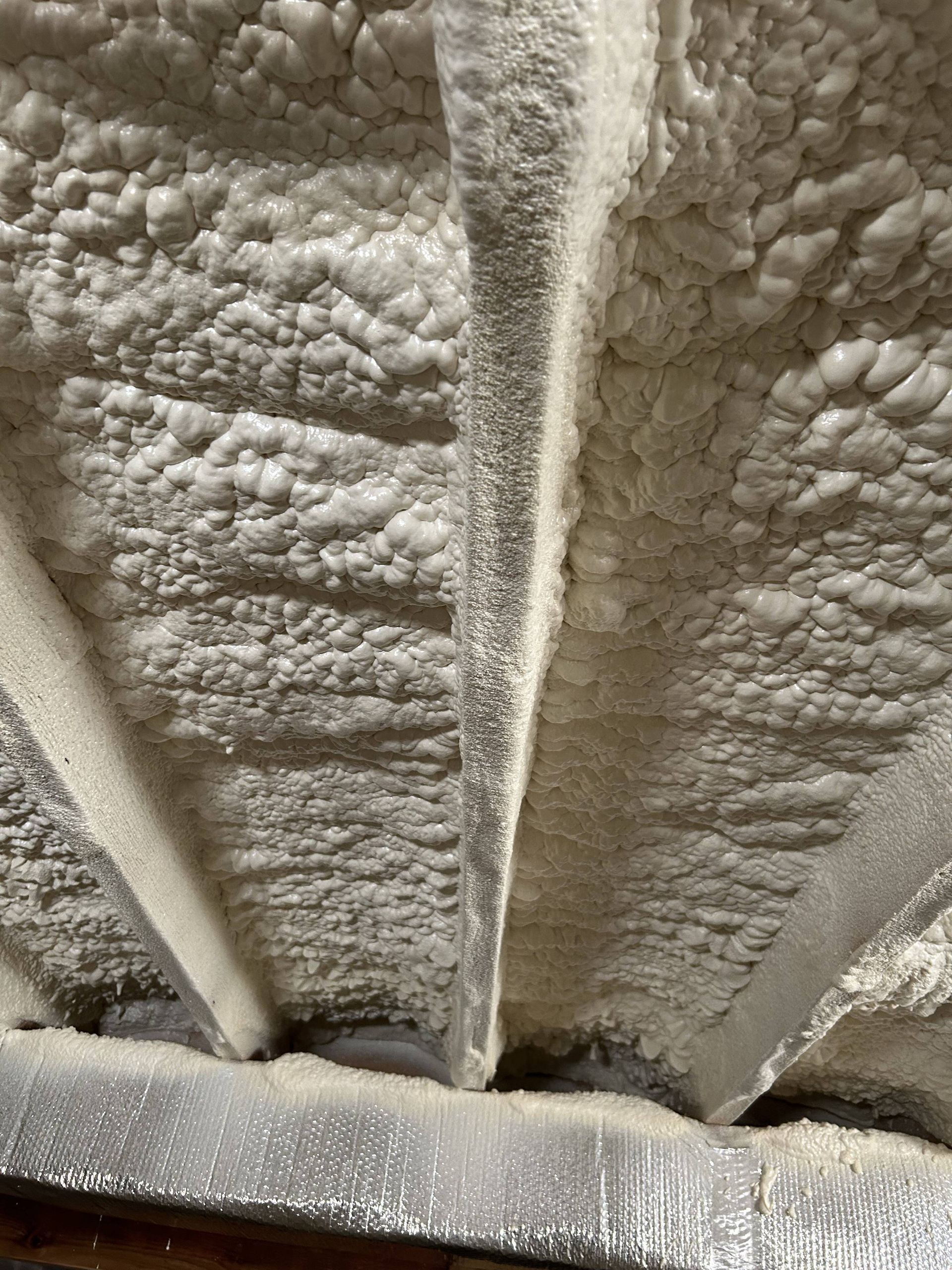 Close-up of a gray, textured wall with vertical beams and a frosted ledge at the bottom