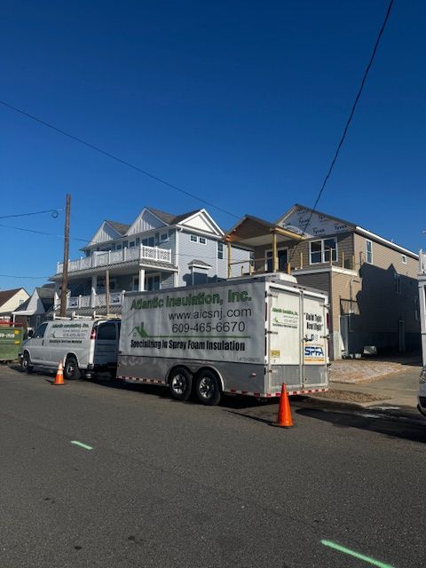 White service truck parked on a sunny residential street beside houses and orange cones