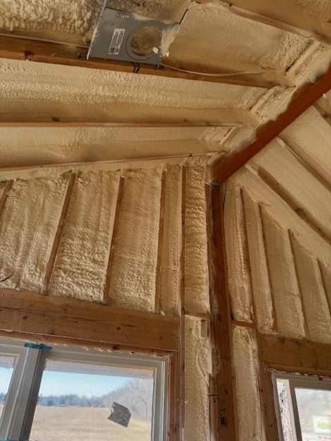 Foam-insulated cabin ceiling with exposed beams and windows below