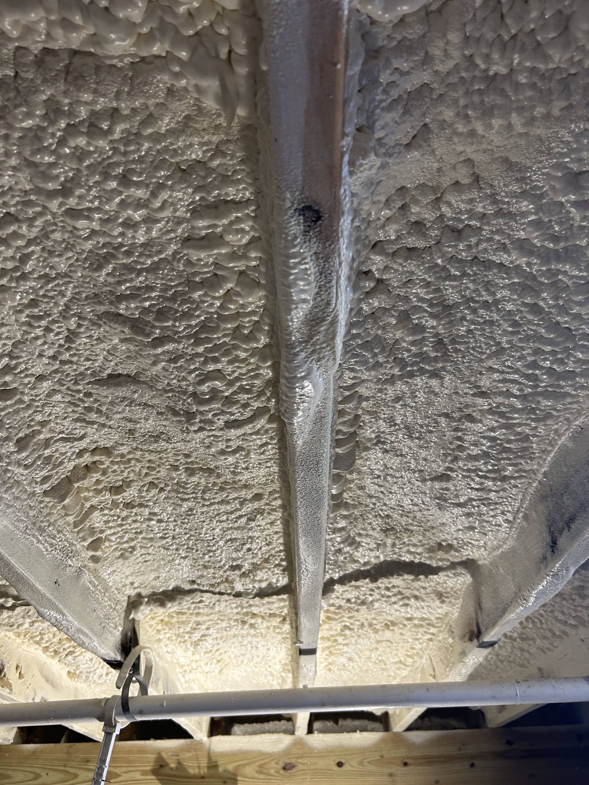 Close-up of a textured gray ceiling with a central seam and a light fixture at the bottom edge