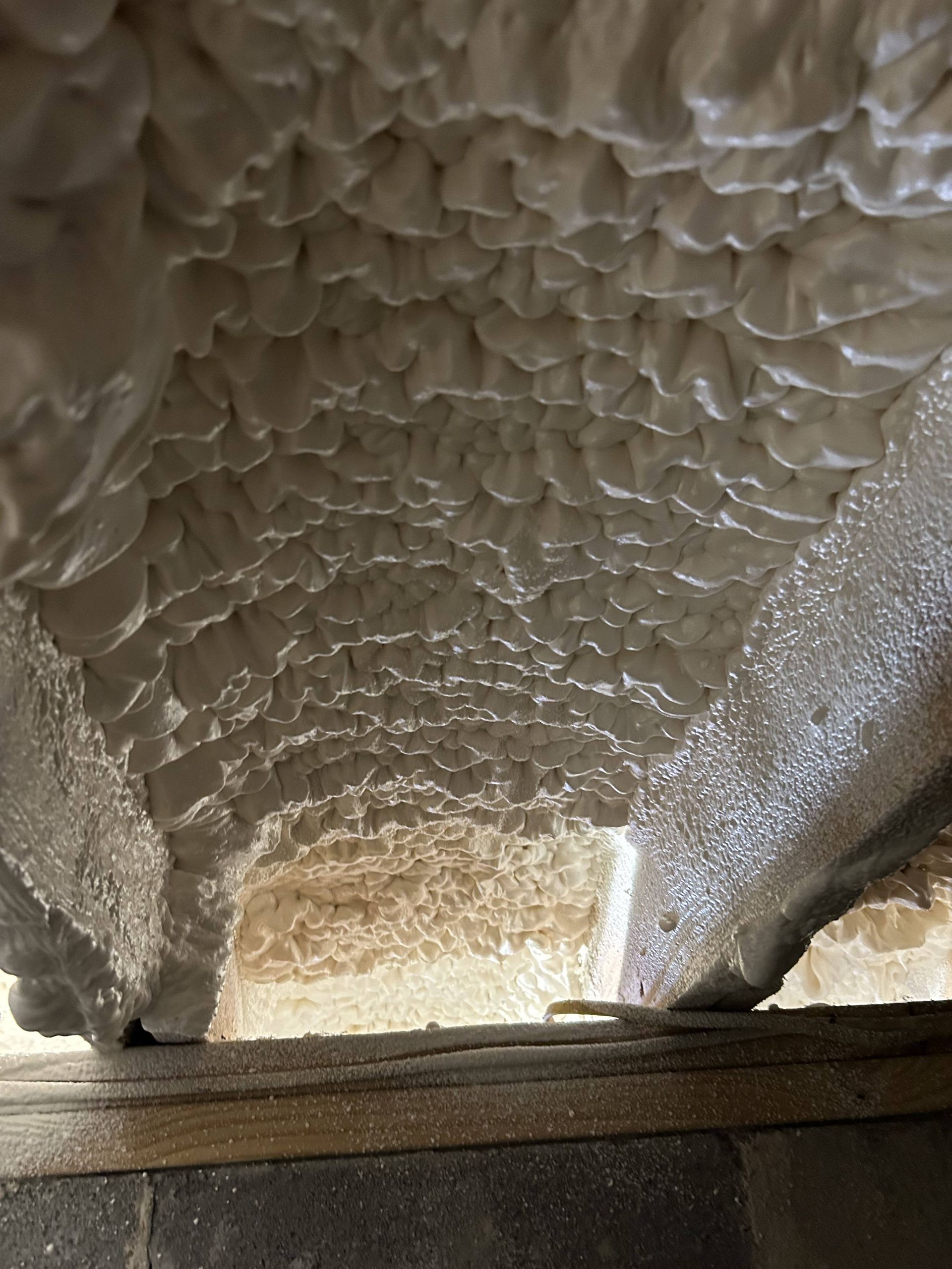 Close-up of a textured, quilted ceiling or insulated tunnel with light at the far end.