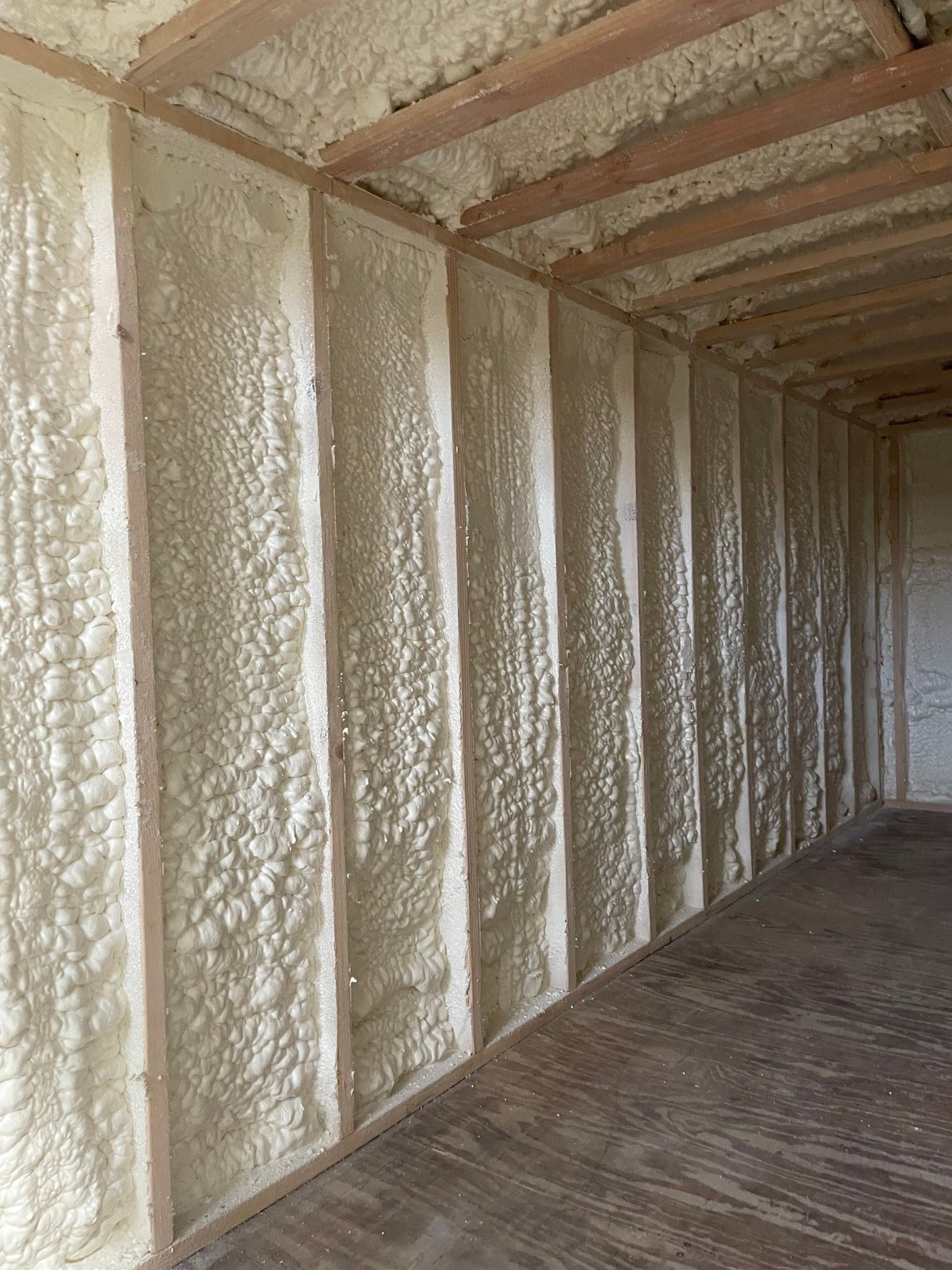 Foam-insulated wall and ceiling inside an unfinished building