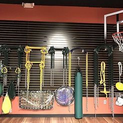 There are many different types of exercise equipment hanging on the wall.