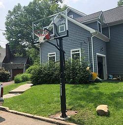 A basketball hoop is sitting in front of a house.