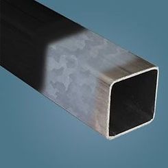 A close up of a square metal tube on a blue surface.