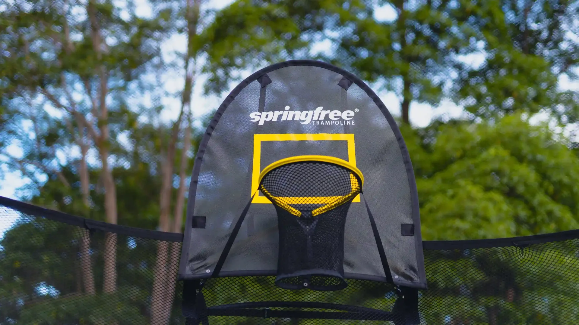 A trampoline with a basketball hoop attached to it.