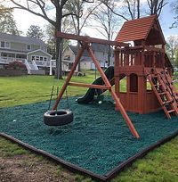 A wooden playground with a tire swing and a slide.
